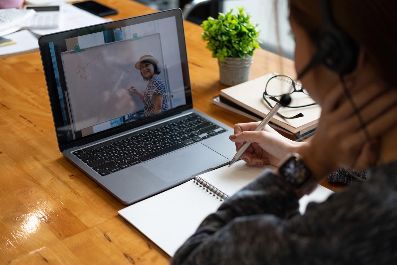 Mulher usando um laptop para realizar uma chamada de vídeo.