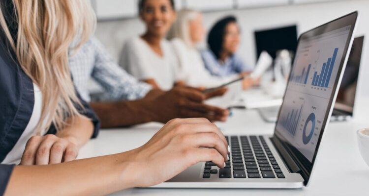 Reunião com gráficos em laptops.
